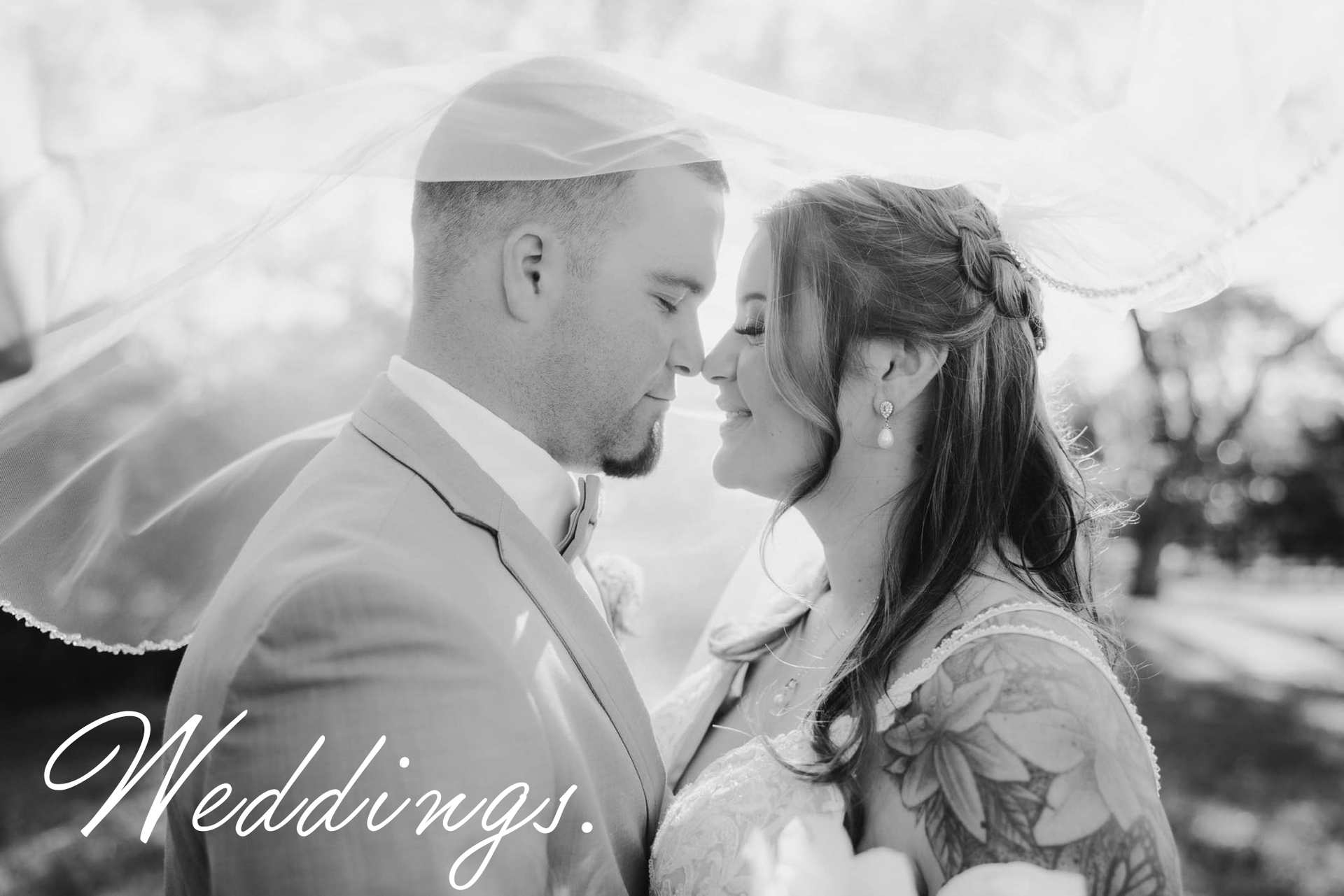 Bride and groom, faces close, under a veil. Black and white photo with the word