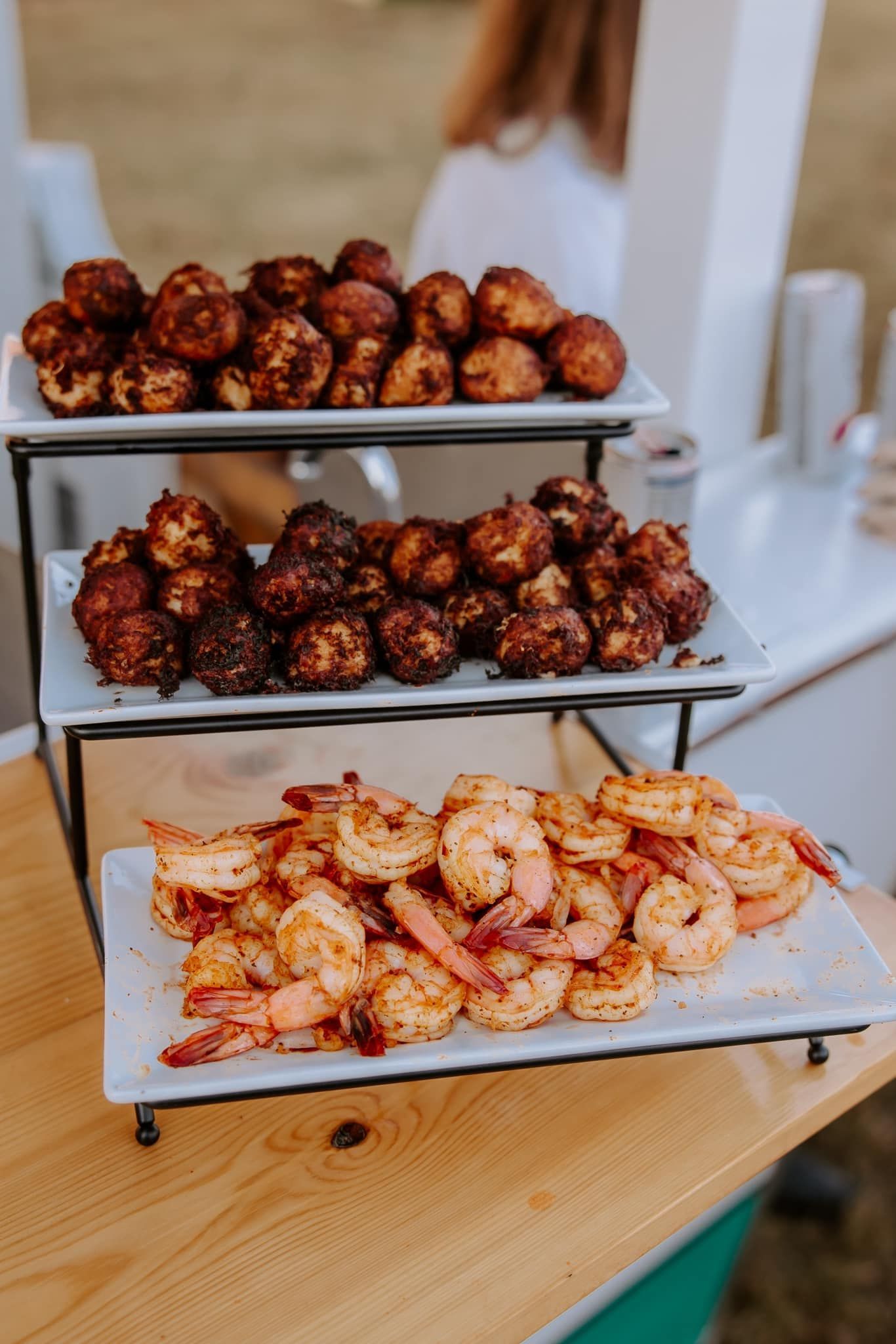 Tiered serving stand with shrimp and fried food.