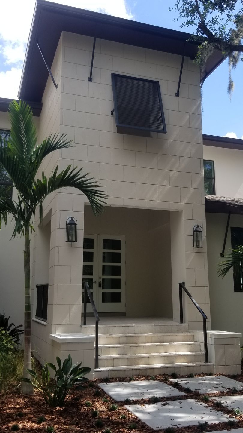 A white house with a palm tree in front of it