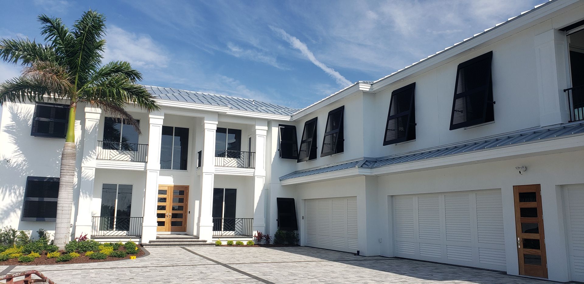 A large white house with a palm tree in front of it