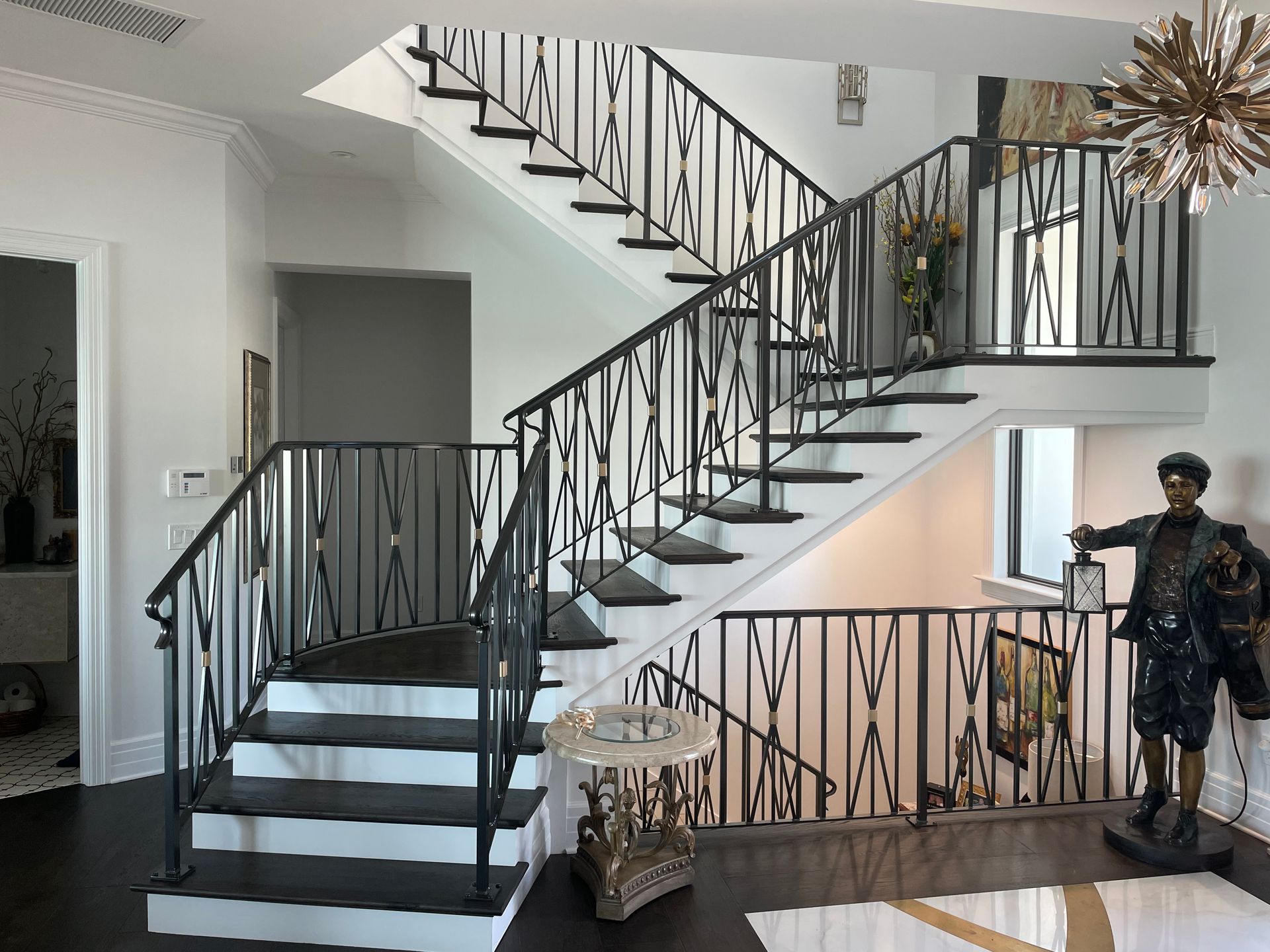 A black and white staircase with a wrought iron railing