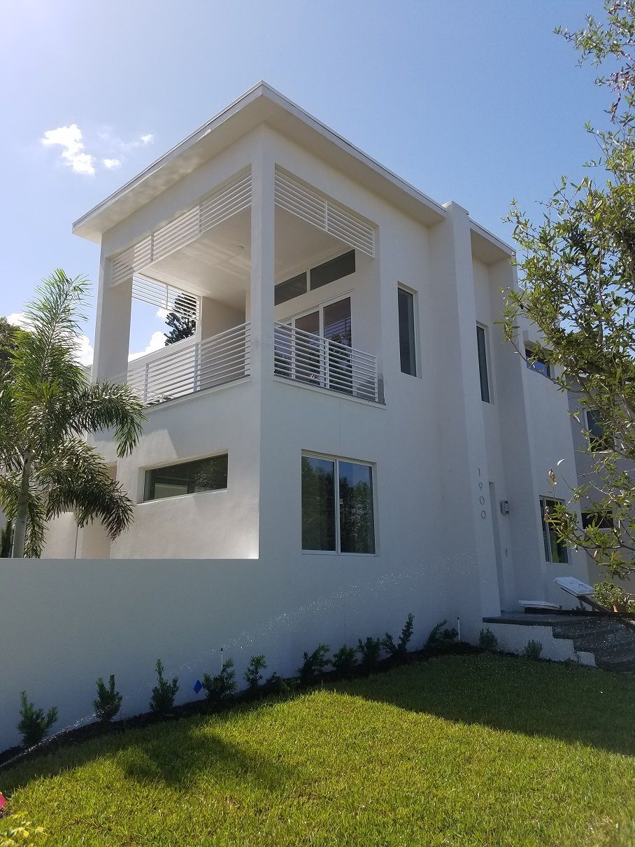 A large white house with a lush green lawn in front of it.