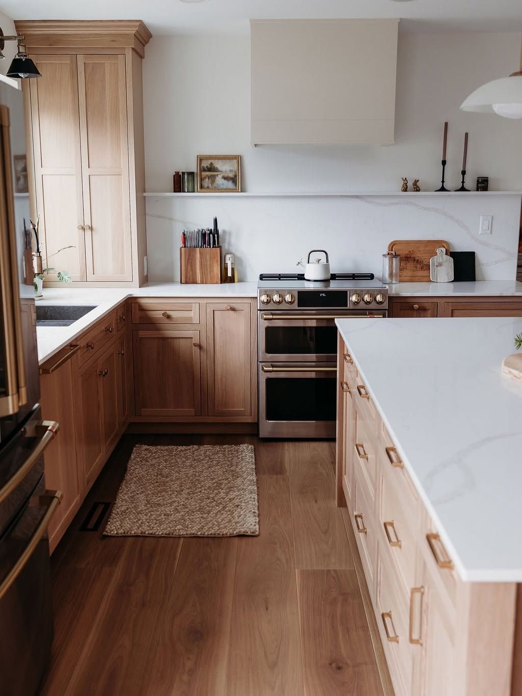 Bright kitchen with wood cabinets, white countertops, and a stove in the center.