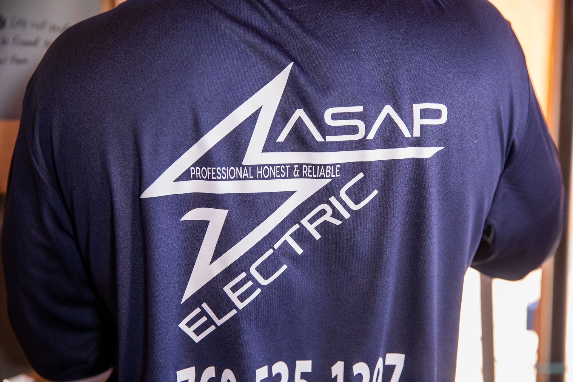 Person labeling electrical wires inside an electrical panel with a marker.