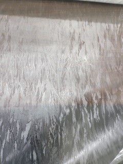 Close-up of a silver-gray fabric or textured surface with soft diagonal sheen.