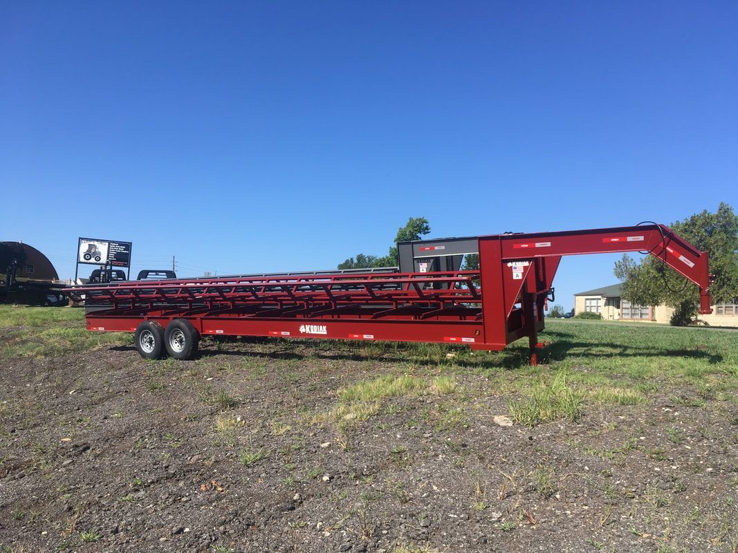 wide view of red hay bale trailer