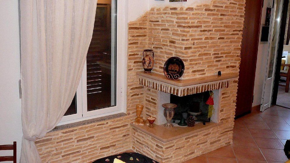 parete accanto al caminetto con intonaco stampato