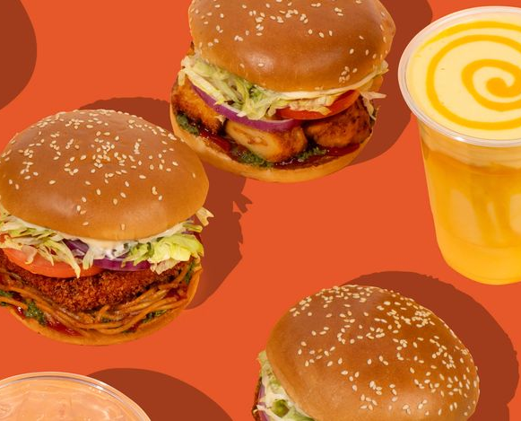 Burgers and a drink on a vibrant orange background.