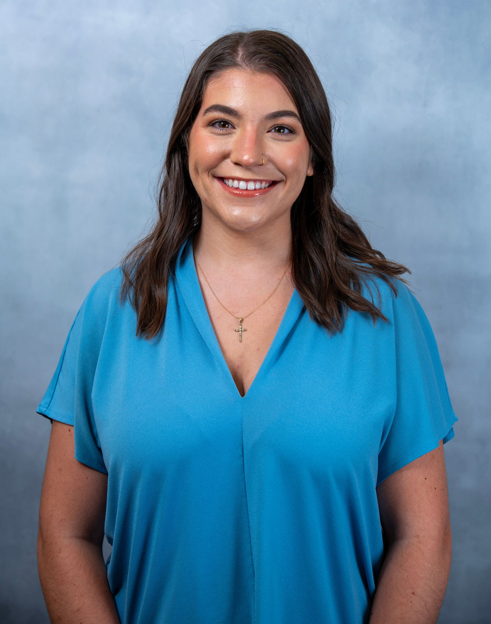 Hailey Wise in a blue shirt against a soft blue studio backdrop.