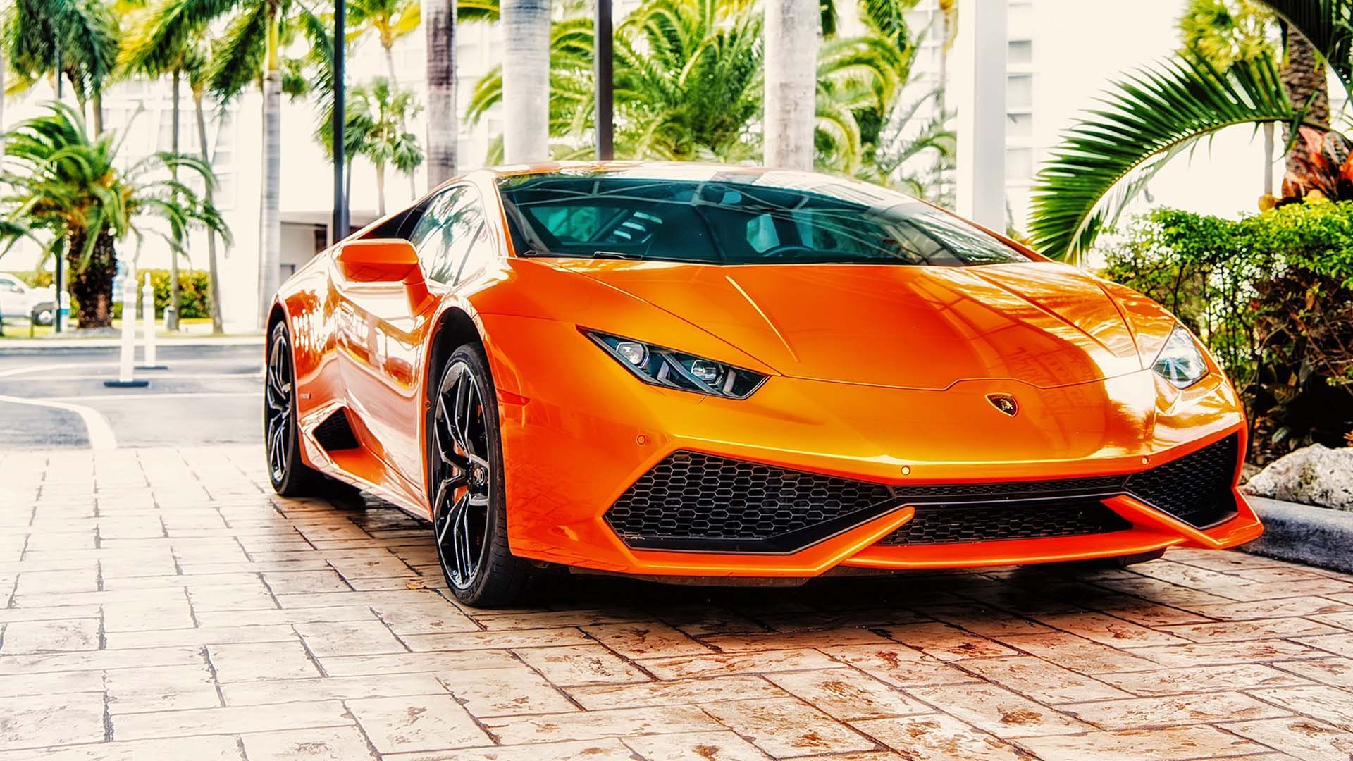a bright orange lamborghini is parked in a parking lot