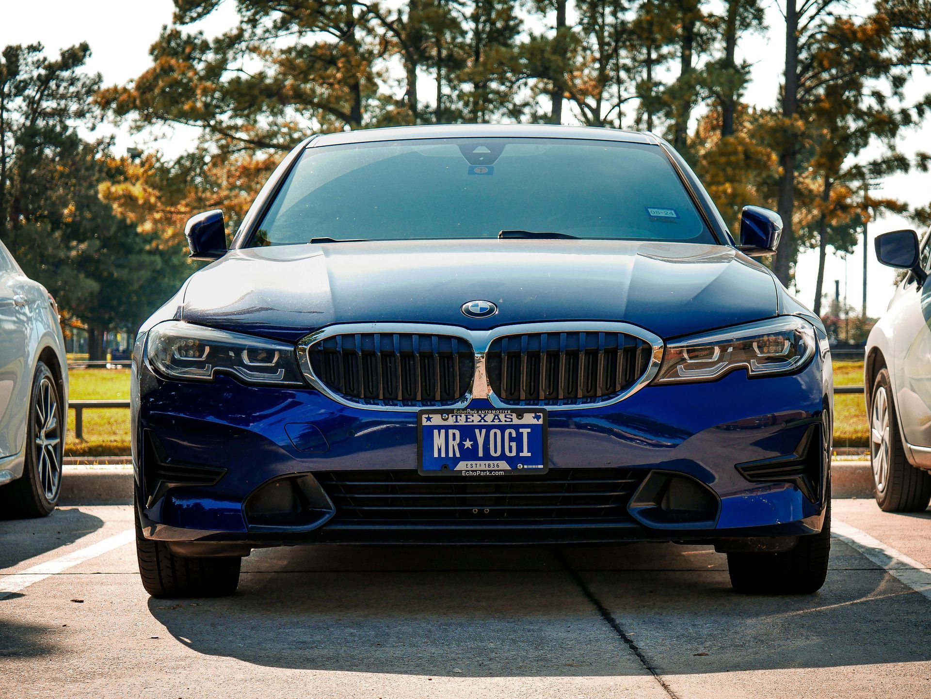 Dark gray BMW sedan with license plate 34 YM 4411 parked outdoors at sunset.