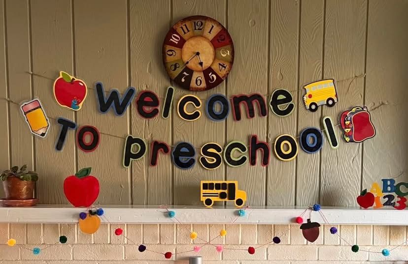 Colorful “Welcome to Preschool” wall display with a clock, school icons, and string lights