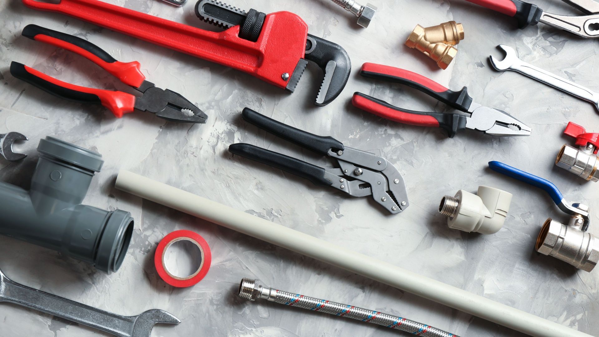 A bunch of plumbing tools are laying on a table.