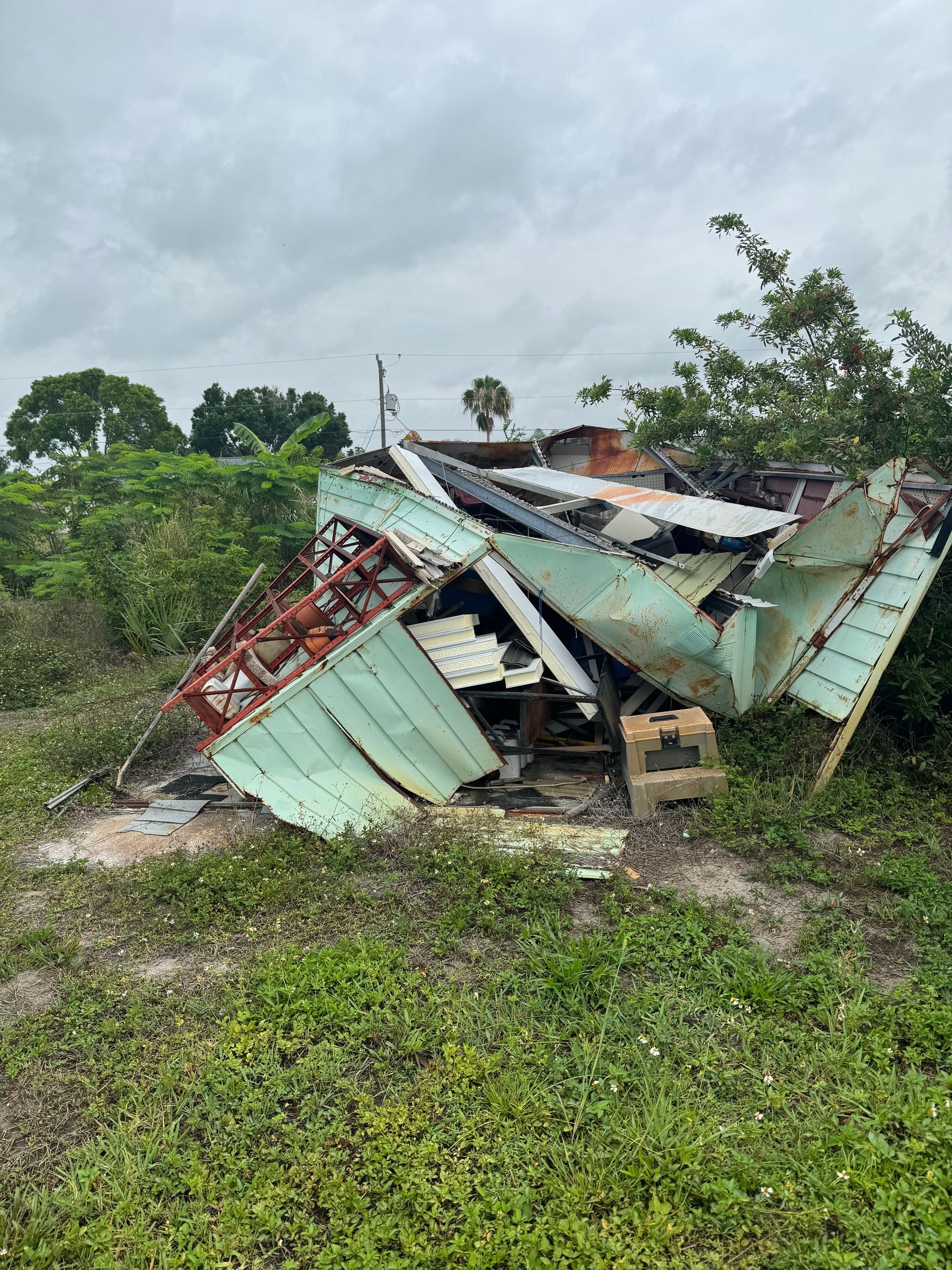 A pile of junk is sitting in the middle of a grassy field.