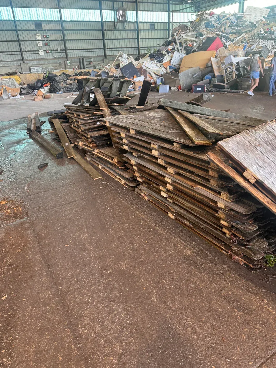 A pile of wooden pallets stacked on top of each other in a warehouse.