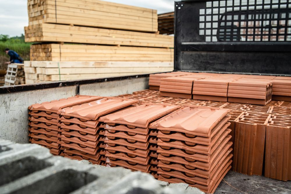 A truck filled with stacks of bricks and wood.