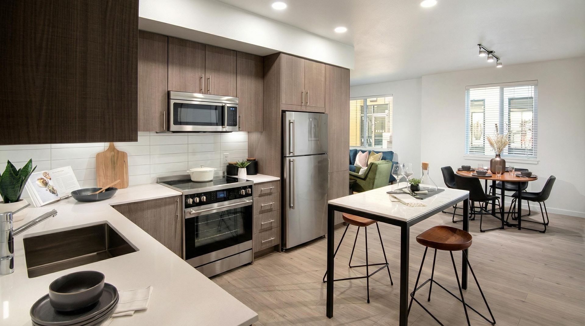 Open-concept kitchen with stainless-steel appliances and an island in a modern apartment.