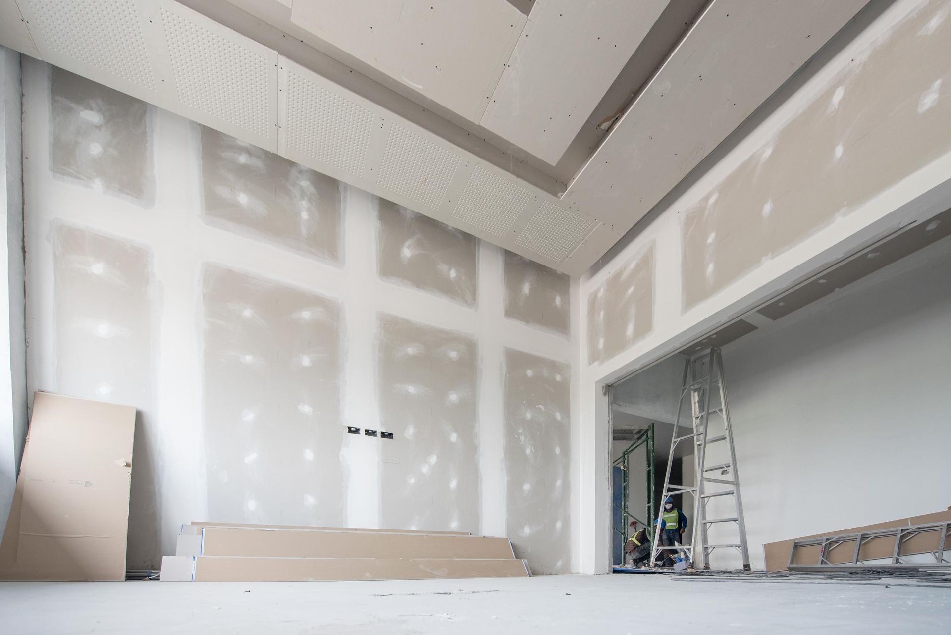 Interior under construction, drywall installed on walls and ceiling. 