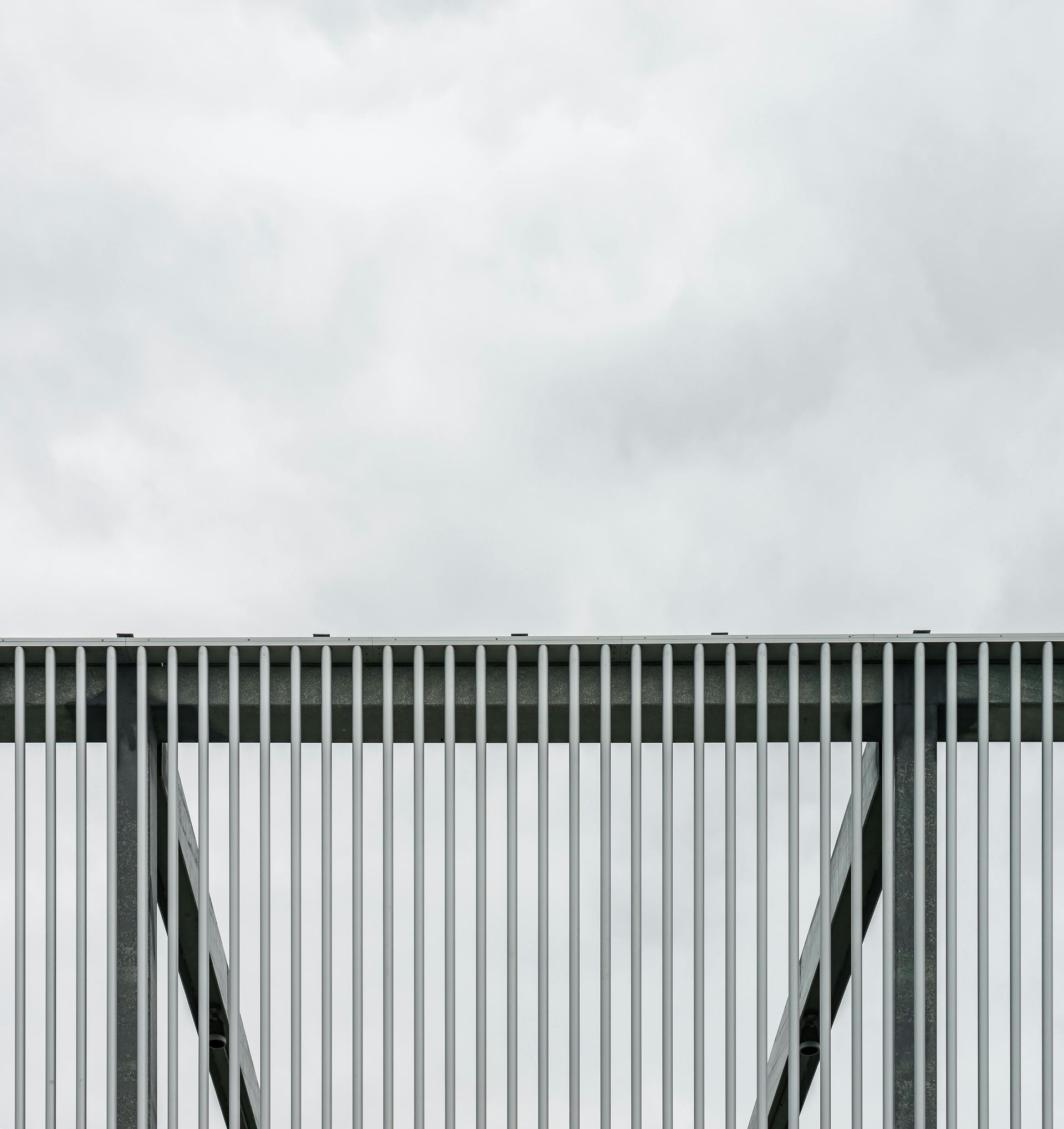 Metal fence against a cloudy sky.