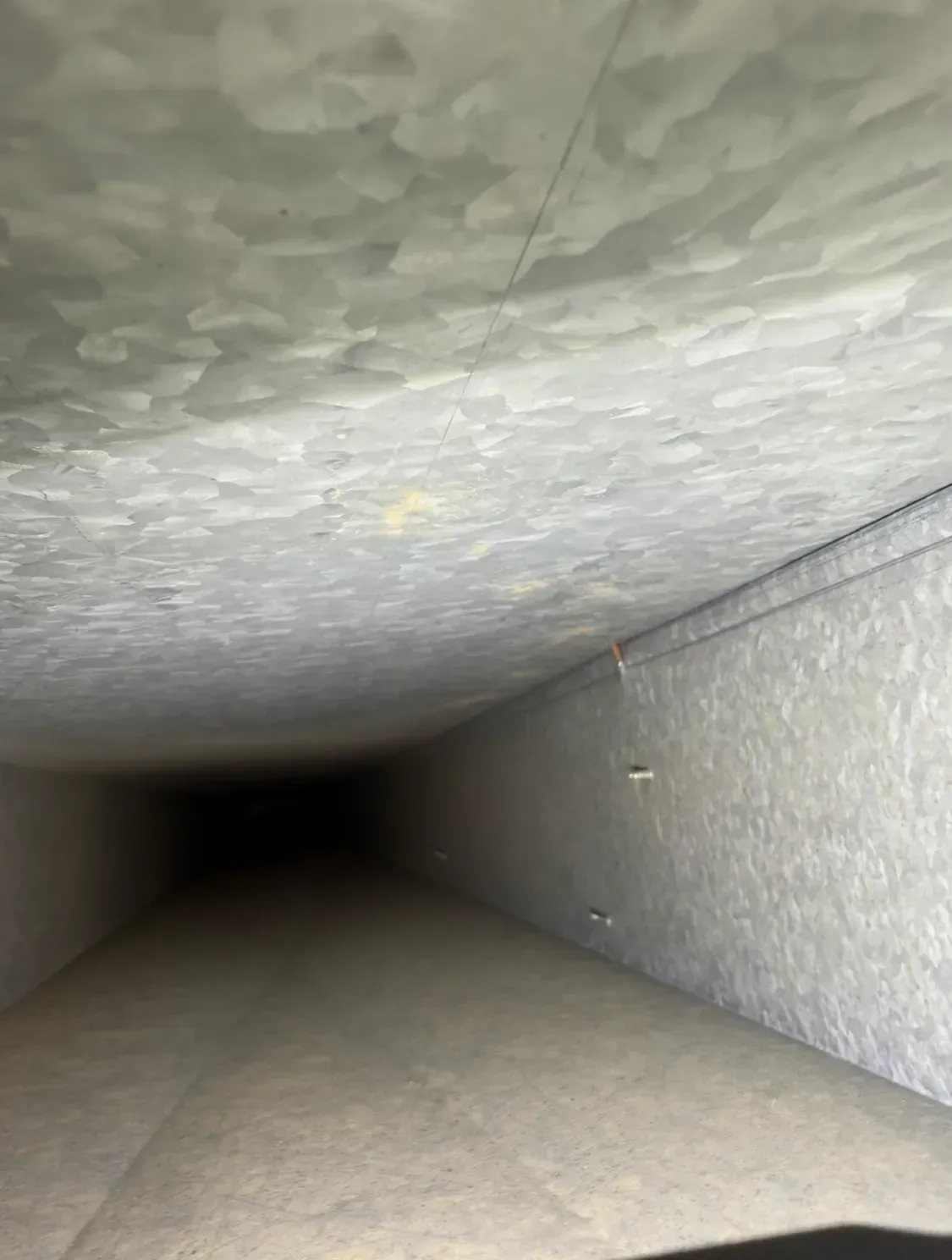 Empty concrete tunnel with textured gray ceiling and walls receding into darkness