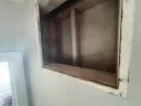Open window with a brown frame and white wall surround.