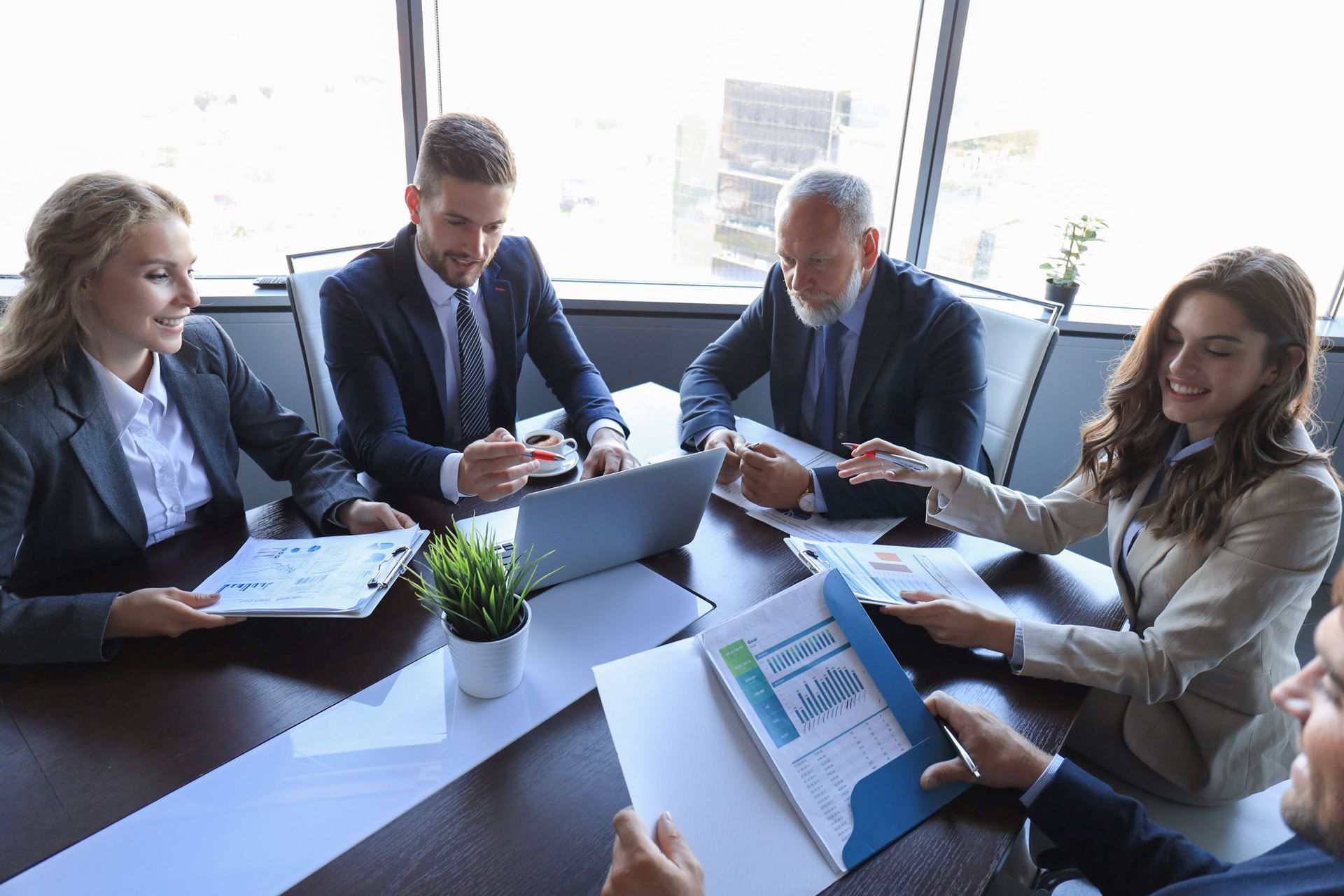 Business team reviewing documents at a conference table in a modern office.
