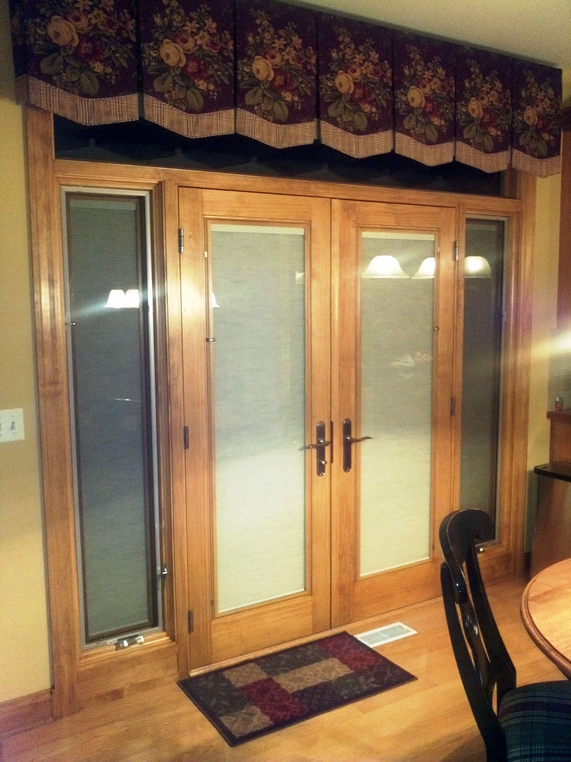 A dining room with sliding glass doors and a rug on the floor