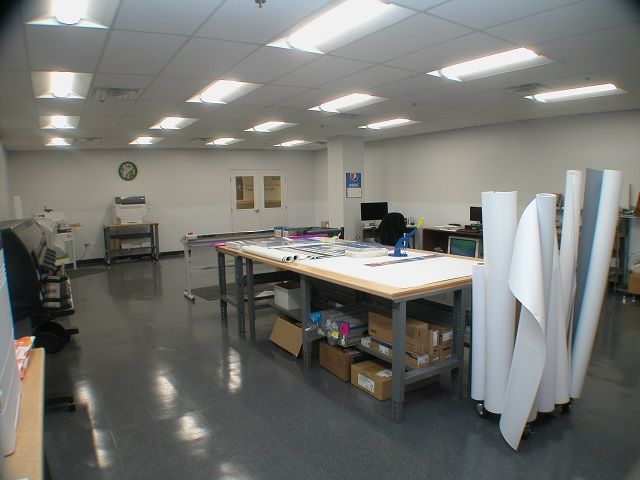 A large room with a table and rolls of paper on the floor