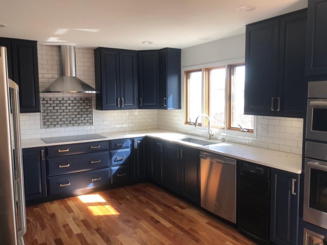 A kitchen with blue cabinets and stainless steel appliances