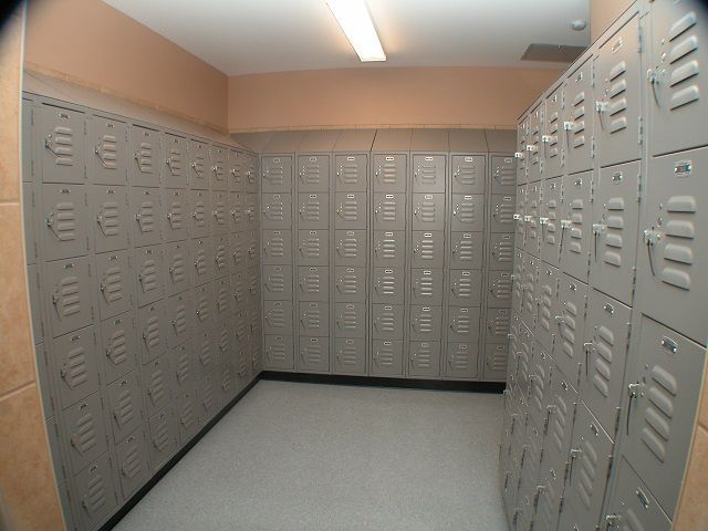 A locker room filled with lots of lockers and a mirror
