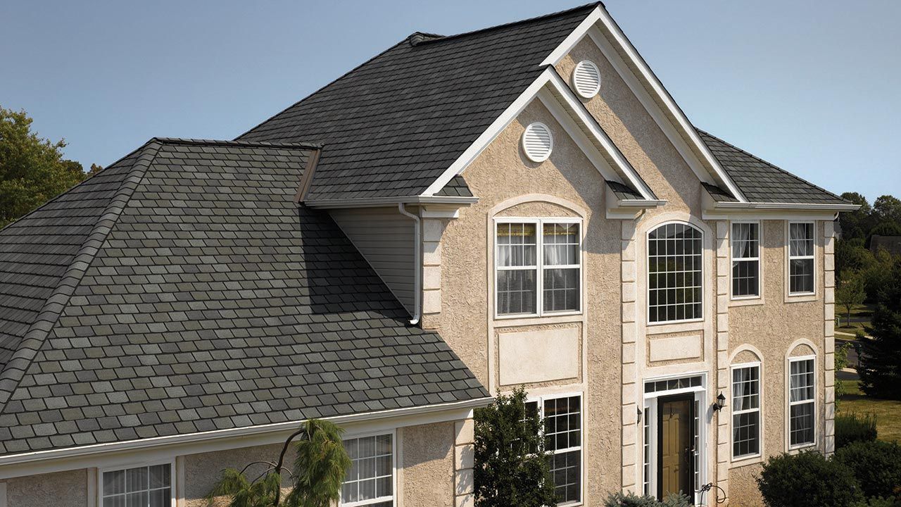 A large house with a black roof and many windows
