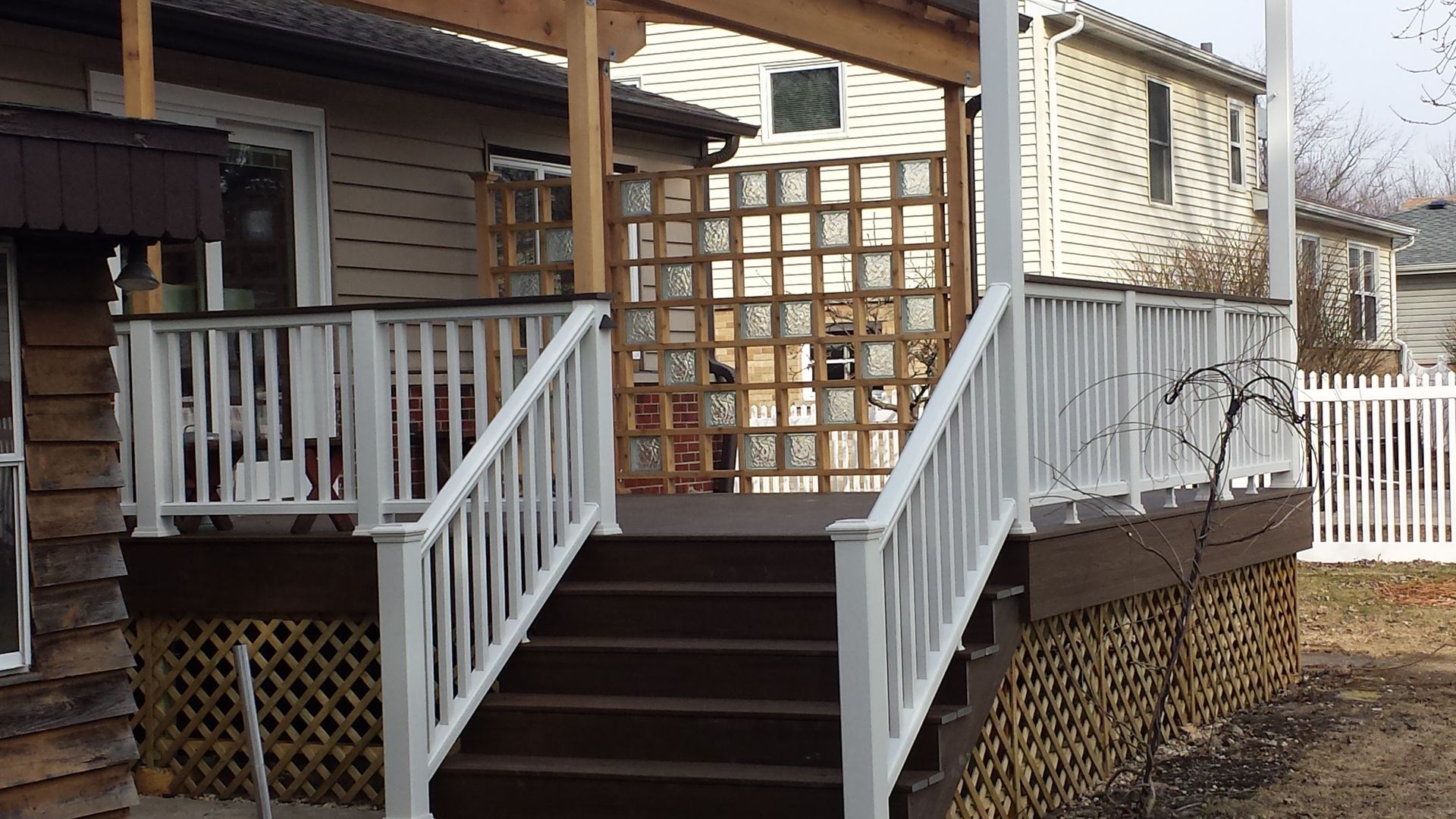 A deck with stairs leading up to it and a white railing
