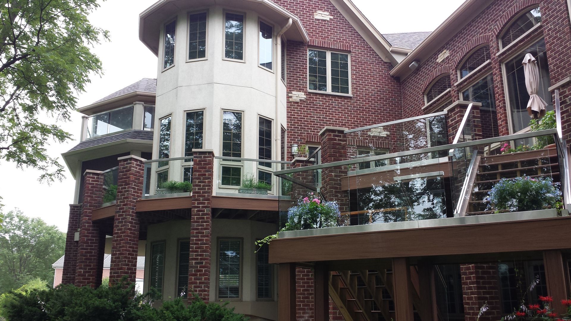 A large brick house with a deck and balconies