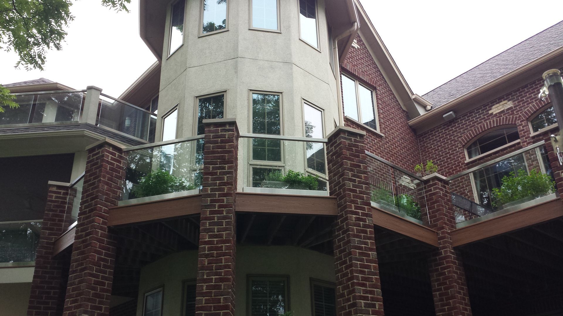 A large brick house with a balcony and a glass railing