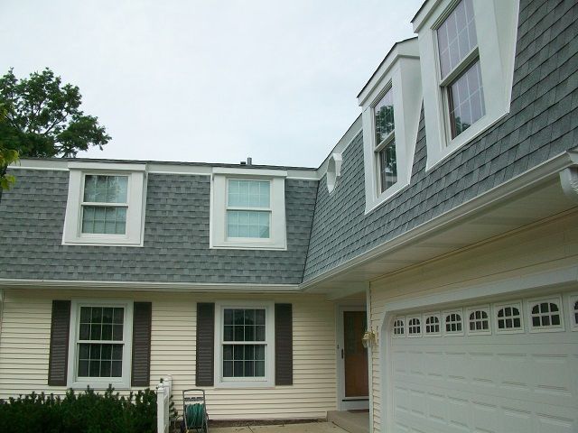 A house with a gray roof and a white garage door