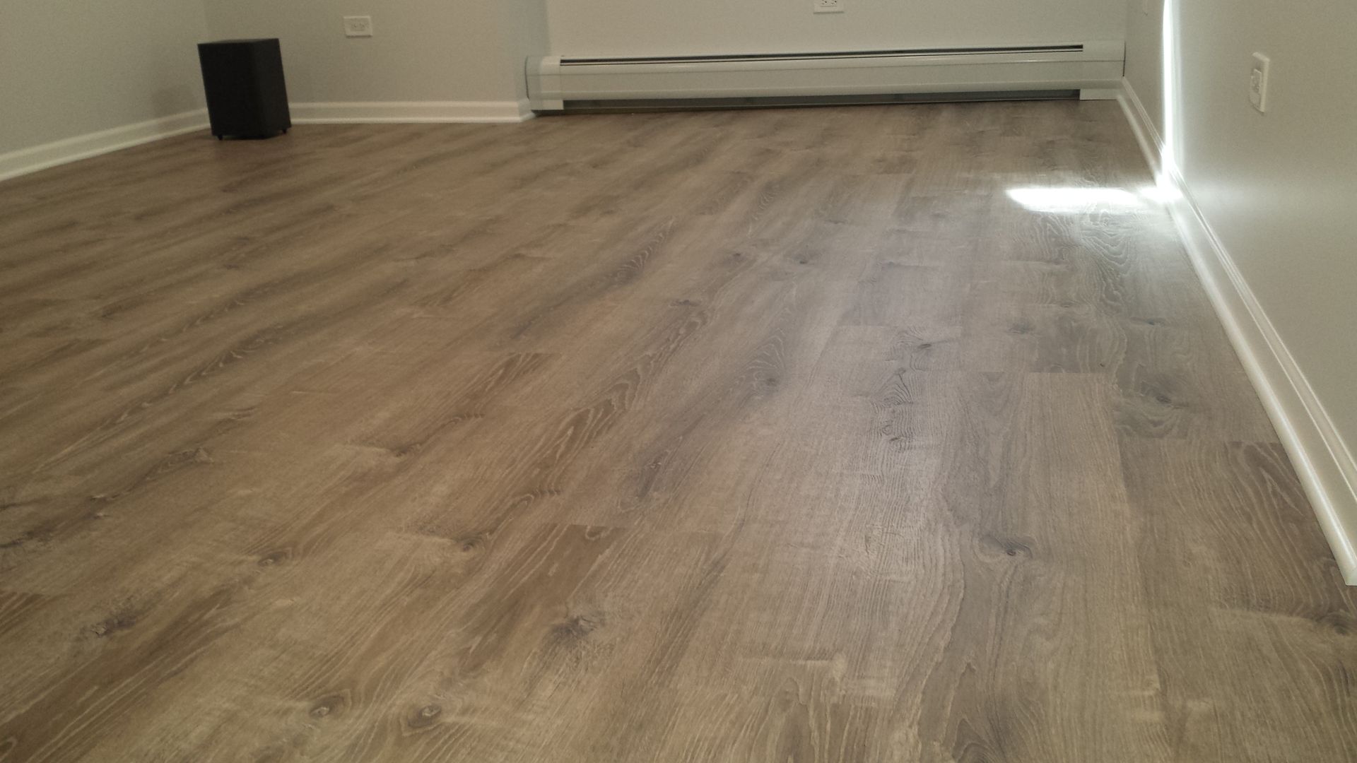A living room with a wooden floor and a radiator.