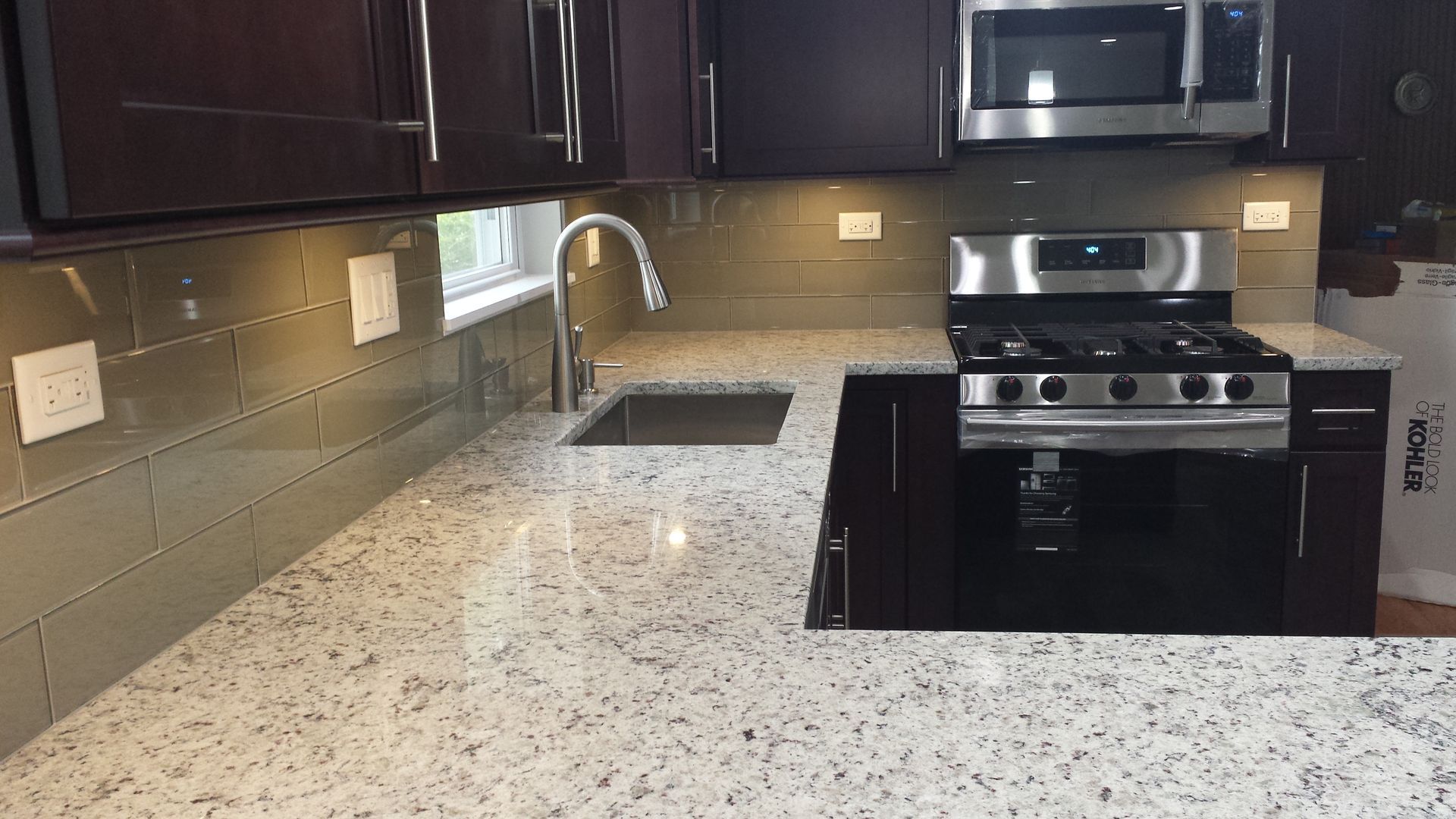 A kitchen with granite counter tops and stainless steel appliances.