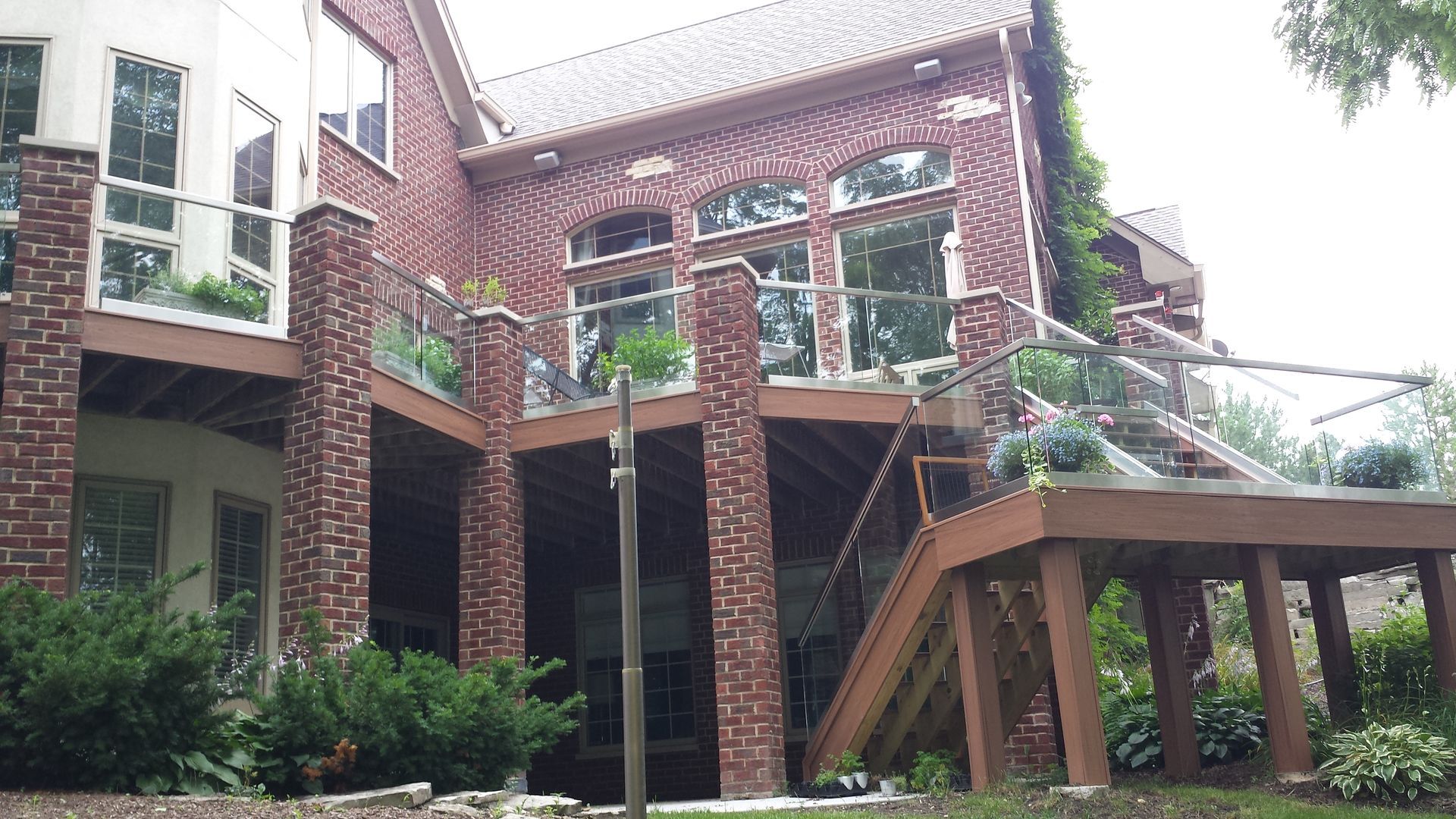 A large brick house with a wooden deck and stairs