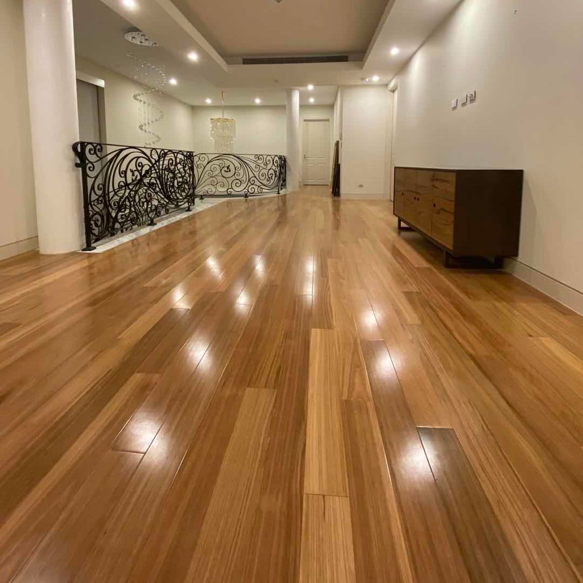 A large room with a wooden floor and a dresser.