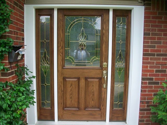 A brick house with a wooden door and stained glass windows