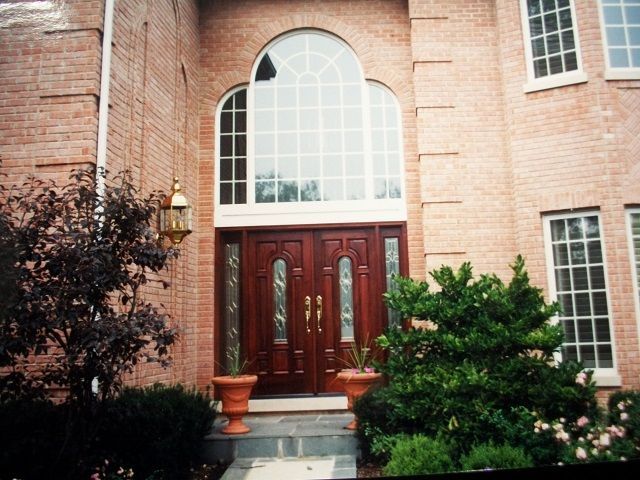 A large brick house with arched windows and a wooden door