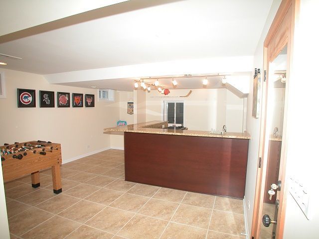 A game room with a foosball table and a bar