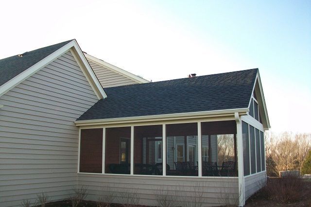 A screened in porch on the side of a house