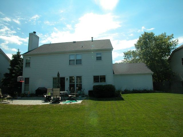 A white house with a basketball hoop in the backyard