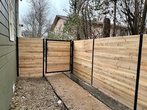 A Wooden Fence With a Gate in the Backyard of a House