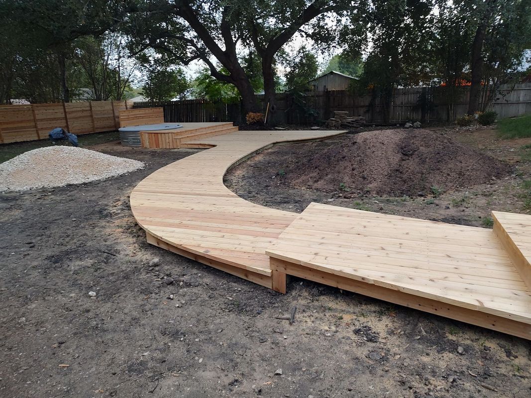 A wooden walkway is being built in a backyard.