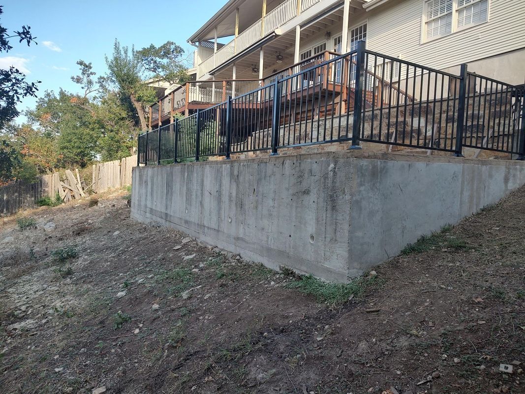 A large house with a large deck and a fence around it.