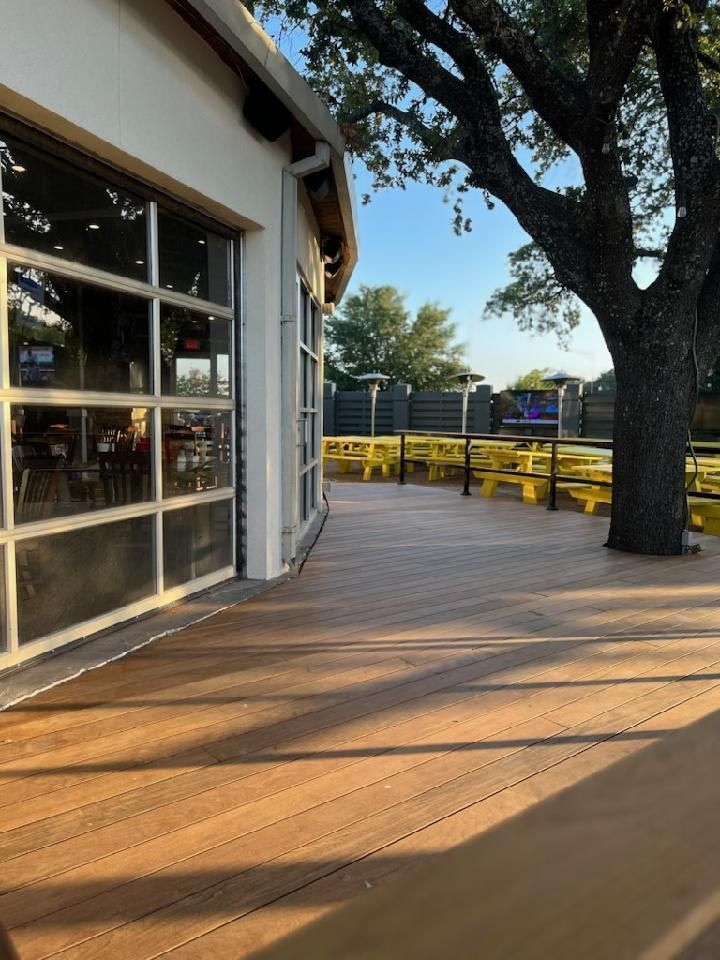 A Large Wooden Deck With a Tree in the Background