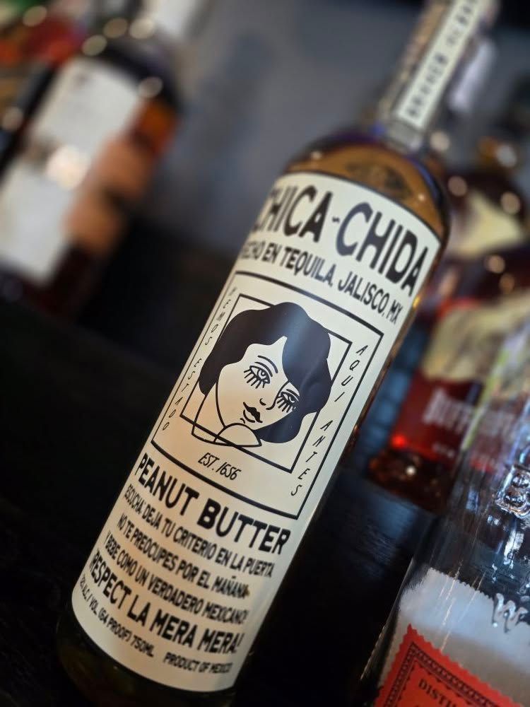 A bottle of chica-chida peanut butter sits on a table