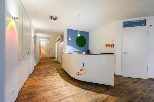 Ein langer Flur mit einer Rezeption in der Mitte.